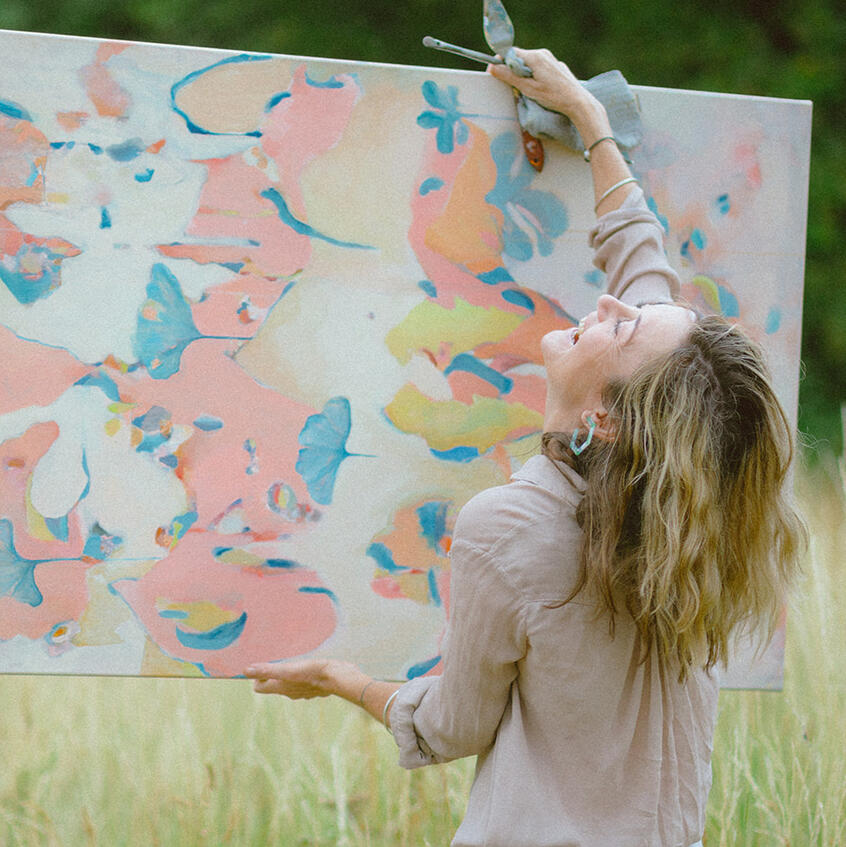 Untitled Branding photoshoot for Lincolnshire artist, holding painting and laughing.